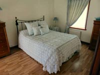 Curtain, cushions, bedspread and bed valance.